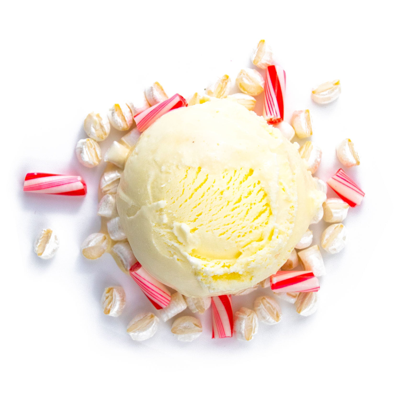 Peppermint Ice cream scoop surrounded by candy canes and cereal on a white background