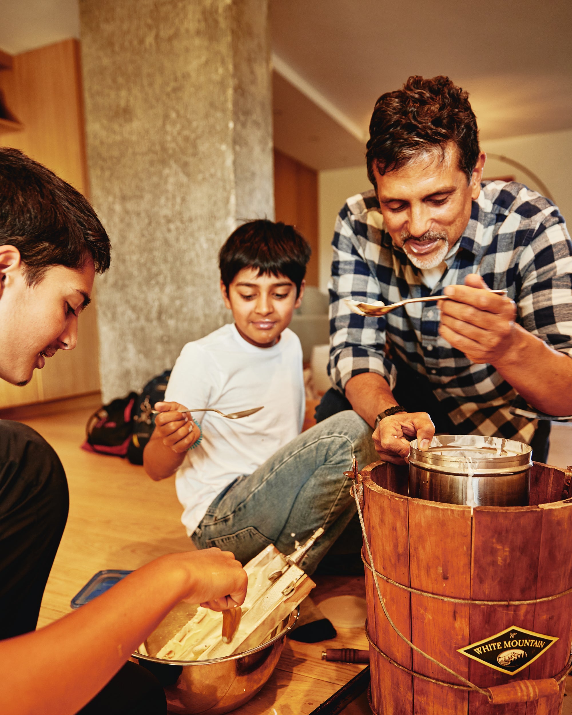 Paul and his kids cooking together in a kitchen using a wooden barrel.